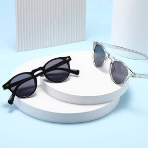 Vue détaillée de lunettes de soleil rondes rétro à monture noire et transparente dorée