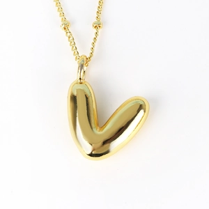 Detailed view of balloon-style gold letter V pendant with bead chain necklace