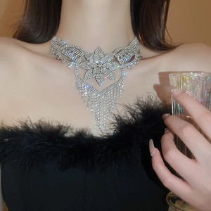 Close-up of floral silver necklace with rhinestone tassels on a female model