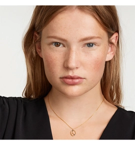 Model wearing gold S925 silver necklace with round zodiac pendant and black gemstone