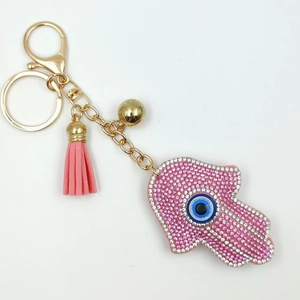 Detailed view of pink rhinestone Hamsa hand keychain with blue evil eye and leather tassel