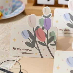 Close-up of die-cut tulip flower greeting card with romantic floral patterns and text