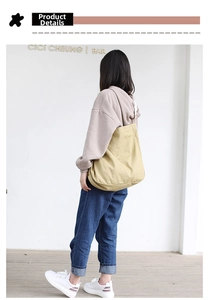 Rear view of a mustard yellow canvas tote bag showing the size and styling on model