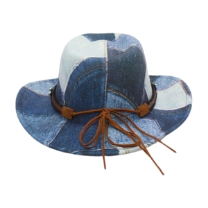 Detail of western cowboy hat with blue denim patchwork and brown decorative ribbon bow