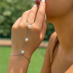Bohemian silver ring bracelet with pearls and rhinestones worn on a hand outdoor