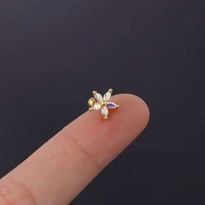 Detailed close-up of rainbow zircon daisy cartilage stud with gold ball screw back