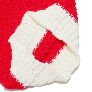 Dettaglio macro del cappello natalizio rosso a maglia grossa con bordo bianco a coste morbide
