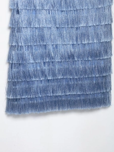 Detailed macro view of layered blue metallic fringe fabric with a silk-like texture
