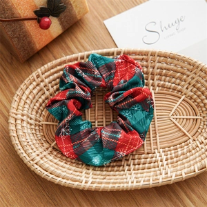 Detail of Christmas scrunchie with red-green plaid and snowflake patterns on a tray