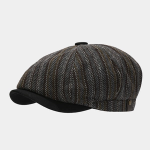 Dettaglio cappello newsboy retrò a spina di pesce con cinturino in pelle e bottone