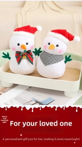 Macro detail of plush Christmas snowman set with festive hats and decorative bows on a tray