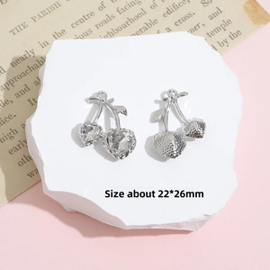 Macro shot of 22x26mm cherry charms with heart-shaped crystals and metallic leaf texture