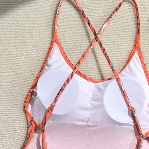 Close-up of orange swimsuit interior featuring removable chest pads and zebra straps