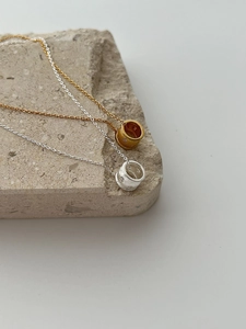 Détail macro de pendentifs cylindriques dorés et argentés gravés d'étoiles sur pierre