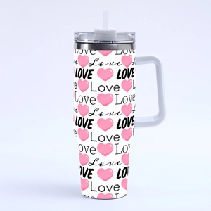 Close-up of 40oz tumbler with pink hearts and black Love pattern on white finish