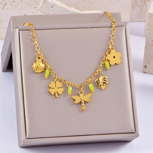 Détail d'un bracelet doré avec pendentifs coccinelle et trèfle sur un présentoir à bijoux