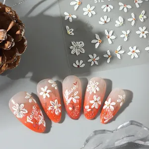 Detailed 5D embossed white daisy nail stickers with orange gradient nails and floral art