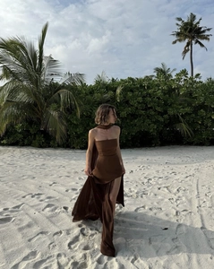 Detail of dark brown strapless maxi dress featuring a high side slit on a tropical beach