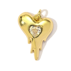 Macro shot of gold fluid-style heart pendant with a central sparkling clear zircon