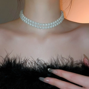 Gros plan d'un collier de perles double épaisseur avec pendentif nœud élégant
