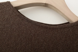 Detail der weichen dunkelbraunen Stricktextur und Rundhalsausschnitt am Holzbügel