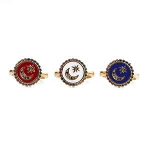 Macro detail of star and moon enamel rings with colorful zircon inlays and golden finish