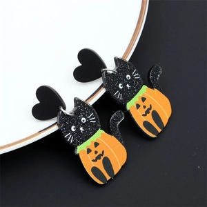 Gros plan de boucles d'oreilles d'Halloween en acrylique chat noir et citrouille