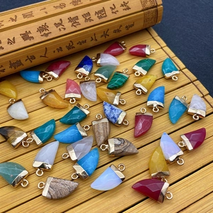 Natural stone chili shaped faceted pendants with gold plated caps on bamboo mat