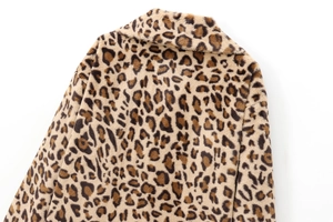Macro detail of plush faux fur leopard print coat collar and premium fabric texture