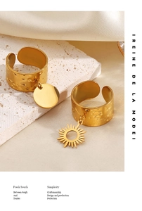 Close-up of 18K gold plated stainless steel sun and round charm rings on stone background