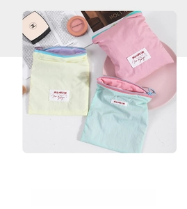 Close-up of three macaron-colored fabric pouches with smooth zippers in a lifestyle setting