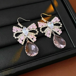 Detailed close-up of bow knot earrings with pink zircon water drop tassels in silver finish
