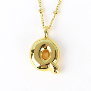 Macro view of a gold Q-letter pendant necklace with a polished metallic finish