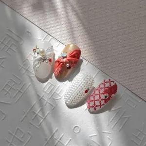 5D embossed press-on nail set featuring pearl lace and red bow designs for manicure