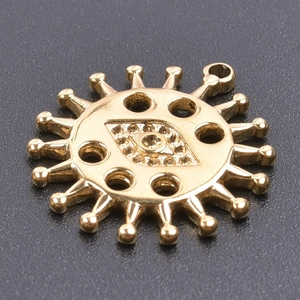 Macro shot of 18k gold plated sun-eye pendant with polished finish on black surface