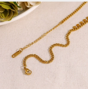 Detail of gold stainless steel necklace with adjustable lobster clasp and round pendant