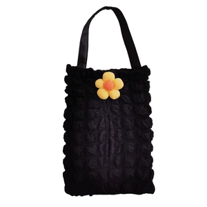 Detail of black bubble texture car tissue holder bag featuring a yellow sunflower decor