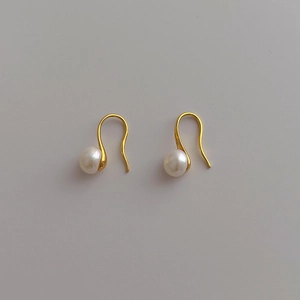 Detail shot of natural freshwater pearl earrings with minimalist gold-plated hooks