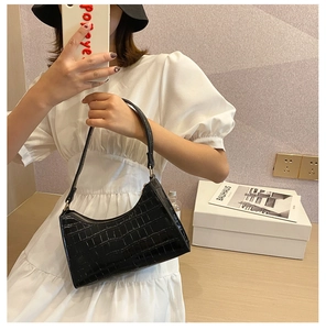 Detail of black crocodile pattern faux leather shoulder bag with crescent moon shape