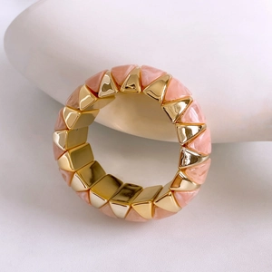 Detail of vintage gold and pink marble geometric triangular link bracelet on white stone