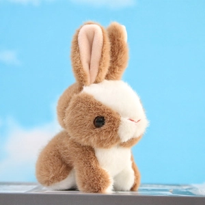 Close-up of the soft plush fur texture and cute face of the brown and white bunny charm