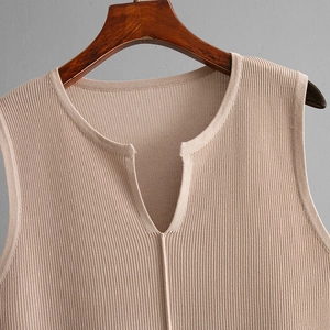 Detail of V-neck sleeveless knitted top showing ribbed texture and khaki fabric finish