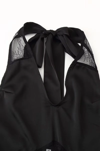 Dettaglio lingerie in raso nero con pizzo raffinato e fiocco da annodare dietro il collo