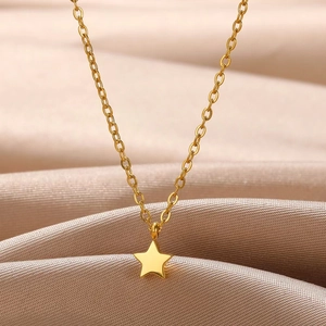 Detailed close-up of golden star pendant necklace on champagne silk background