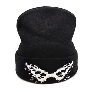 Detail of black knit beanie featuring white jacquard pattern and folded cuff texture