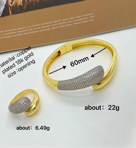 Detail of 18K gold plated copper jewelry set with teardrop zircon pavé on magazine background