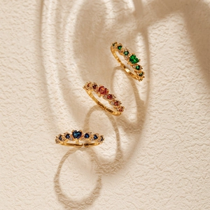 Detailed macro view of three heart-shaped gemstone rings with 18K gold plated texture