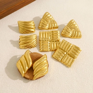 Macro detail of high-end 18K gold stainless steel earrings with square and wavy textures