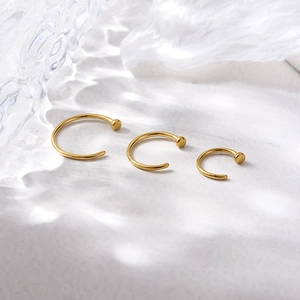 Three premium golden G23 titanium C-shaped nose rings in different sizes on white background