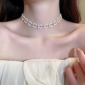 Gros plan du collier ras du cou en perles montrant les détails floraux élégants